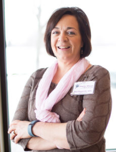 Rita Hagen wearing a brown shirt with pink scarf