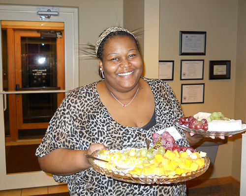 Event volunteer holding two fruit platters