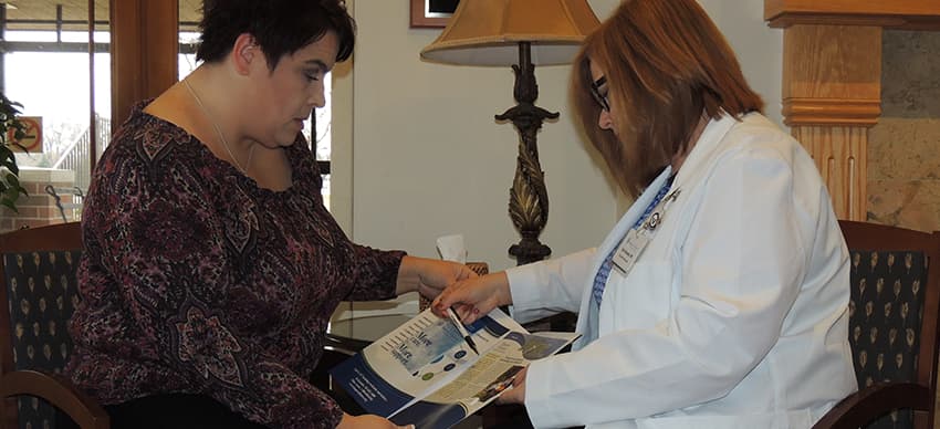 Hospice nurse looking over a pamphlet with a woman