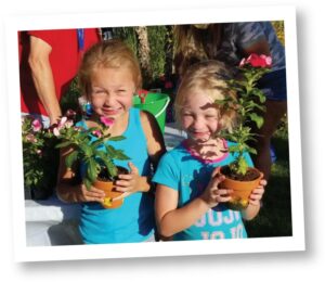 Two young girls holding potted plants at our Planting Memories event